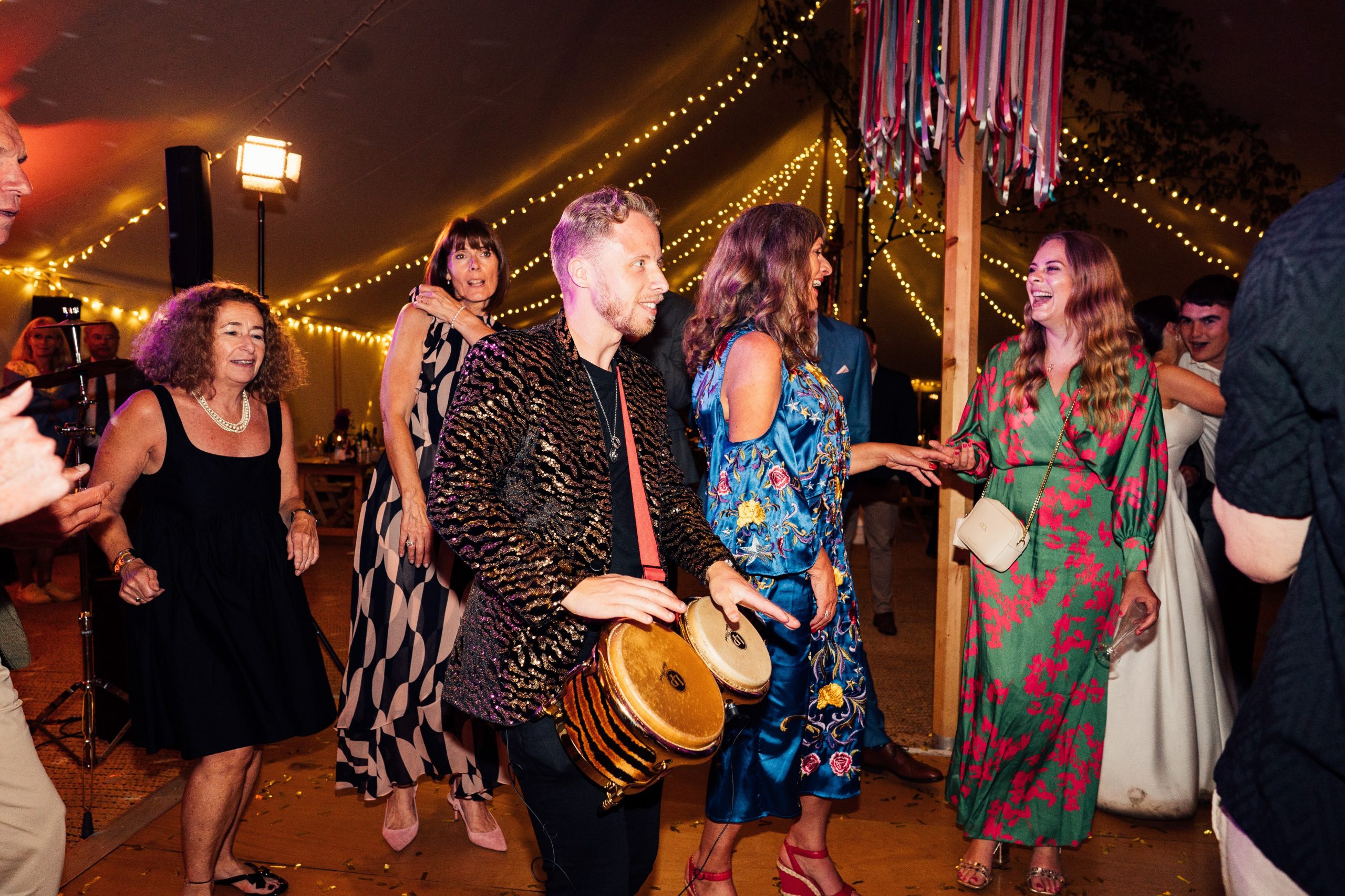 DJ with percussion and bongo players performing live at an Essex event